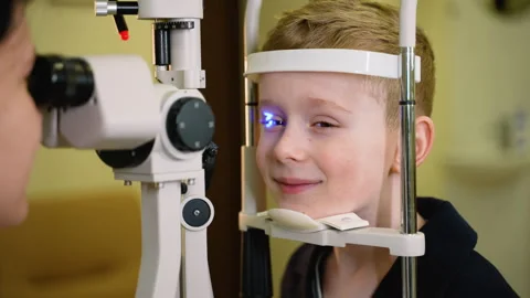 Young boy undergoing slit lamp eye exam Stock Footage 310809185