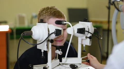 Young boy undergoing synoptophore eye examination by doctor Stock Footage 310808121