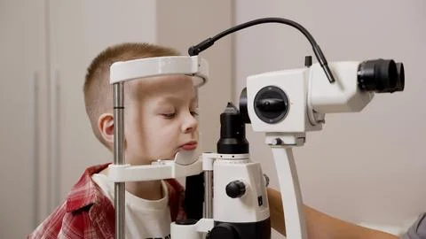 Young boy undergoing a vision test with a slit lamp at an ophthalmologist c.. 库存照片