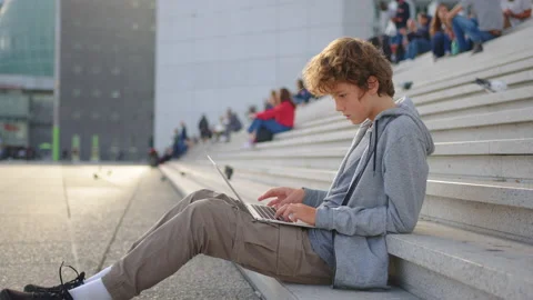 Young boy university student studying online using laptop computer, taking notes Stock Footage 221024258