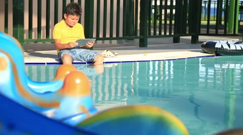 Young boy using digital tablet near the pool 6 Stock Footage 64805514