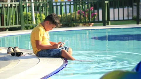 Young boy using digital tablet near the pool 9 Stock Footage 65216300