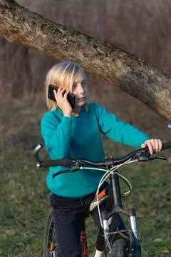 Young boy using a mobile phone, communicating while standing next to his bi.. Stock Photos