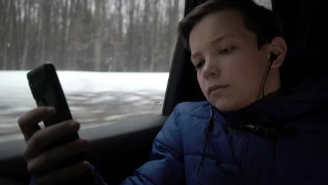 Young boy using smartphone during taxi ride in city Stock Footage 104374241
