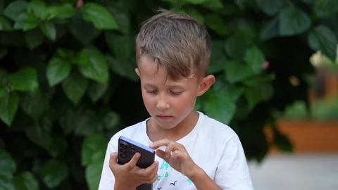 Young Boy Using Smartphone Outdoors Stock-Footage 342621529