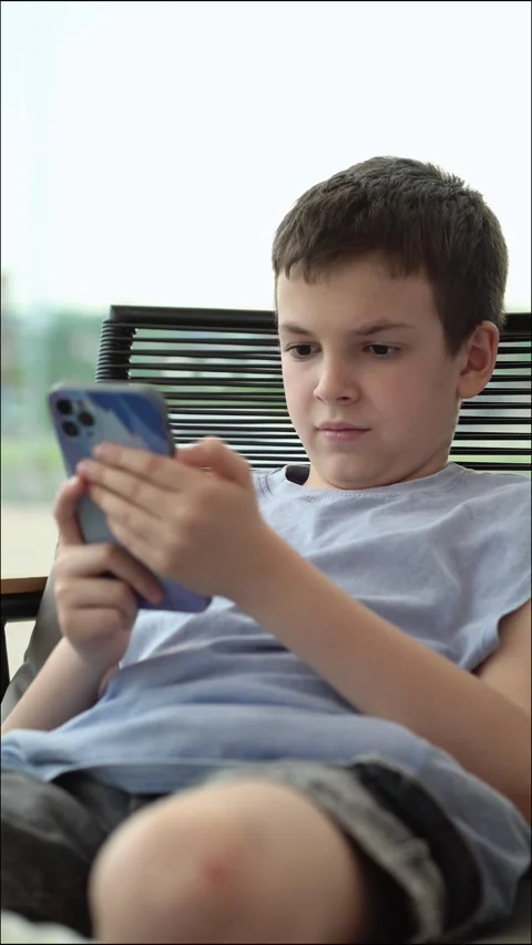 Young boy using smartphone preteen child concentration serious expression screen Stock-Footage 336822808