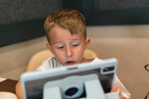 Young boy using tablet computer indoors close up portrait Stock Photos