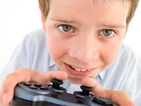 Young boy using videogame controller smiling Stock Photos