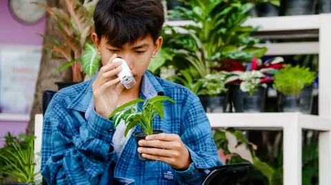 Young boy is using a white small microscope to inspect and to study plants Stock Photos