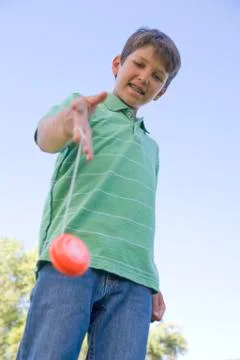 Young boy using yo yo outdoors smiling Stock Photos