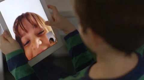 Young boy video chats with his sister on a tablet Stock Footage 45869991