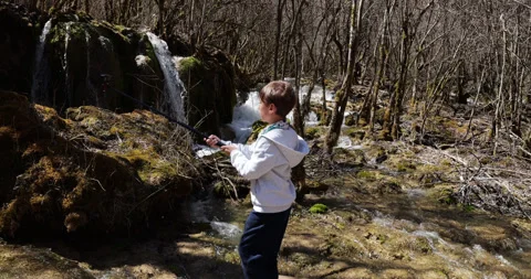 Young boy vlogging with action camera at Jiuzhaigou waterfalls, slow motion Stock-Footage 321233995