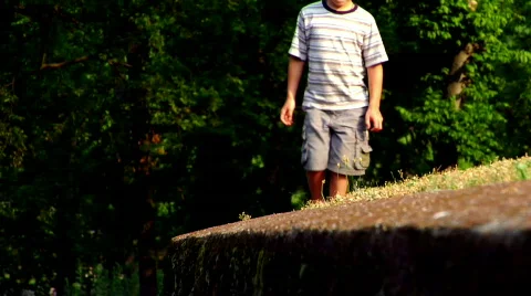 Young Boy Walking Along a Wall Stock Footage 371708
