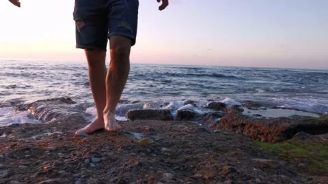 Young boy walking on the beach at sunset Stock Footage 130563082
