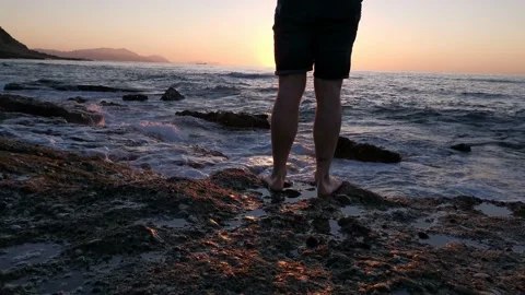 Young boy walking on the beach at sunset Stock Footage 130563109
