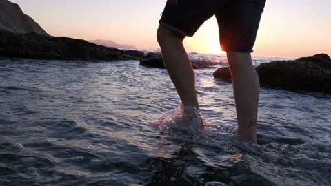 Young boy walking on the beach at sunset Stock Footage 130563174