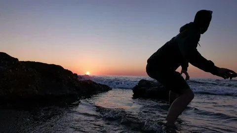 Young boy walking on the beach at sunset Stock Footage 130563206