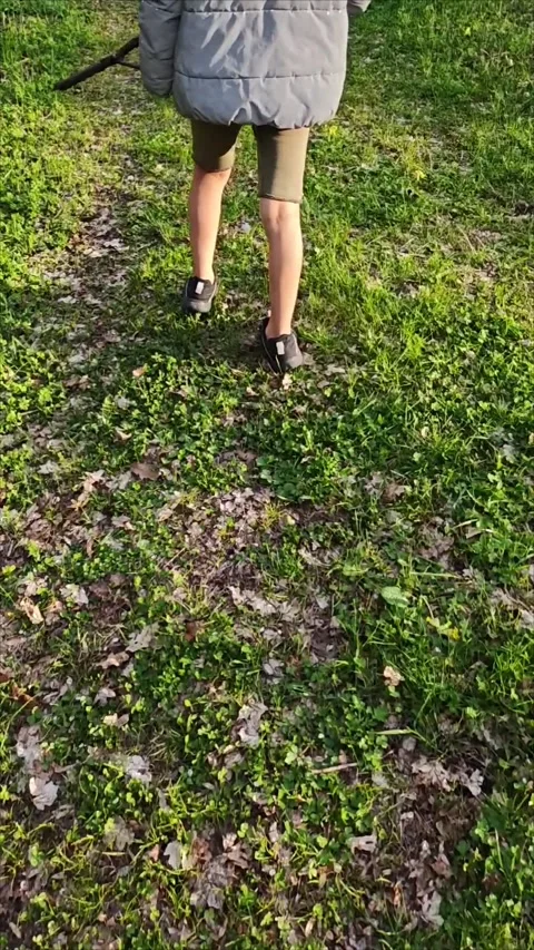 Young boy walking in park, using hiking stick for support Vidéo 307495525