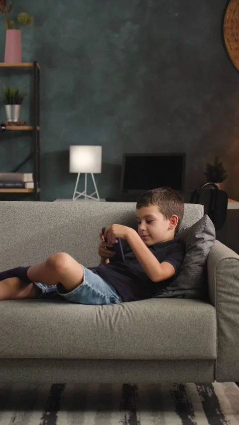 Young Boy Walking to Sofa to Use Smartphone Video stock 344147134