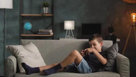 Young Boy Walking to Sofa to Use Smartphone Stock-Footage 344147144