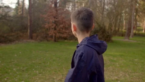 A Young Boy Walking Thoughtfully Through Lush Nature and Forests Stock Footage 311204924