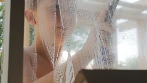 A young boy washes the windows at the window on a sunny summer day.  Stock Footage 156517528