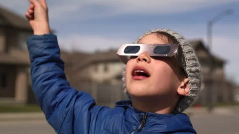 Young boy watching solar eclipse with special glasses very excited Stock Footage 271315298