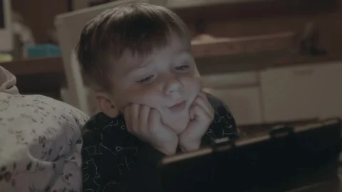 Young boy watching a tablet screen, transfixed on the content. Stock Footage 101554297