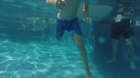 Young boy waves underwater at camera Stockbeeldmateriaal 94225529