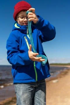A young boy wearing a blue jacket and a red hat under sunny skies Foto stock