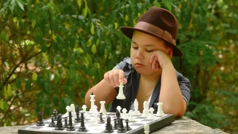 Young Boy Wearing Hat Playing Chess and Making Move. Stock-Footage 343550223