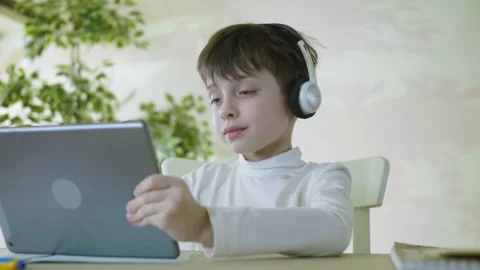 Young Boy Wearing Headphones Using Tablet at Home. Stock Footage 301174483