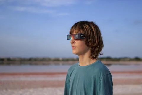 Young boy wearing solar eclipse glasses, looking up at the sky in anticipat.. Stock Photos