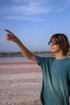 Young boy wearing solar eclipse glasses points at the sky while observing a.. Stock Photos