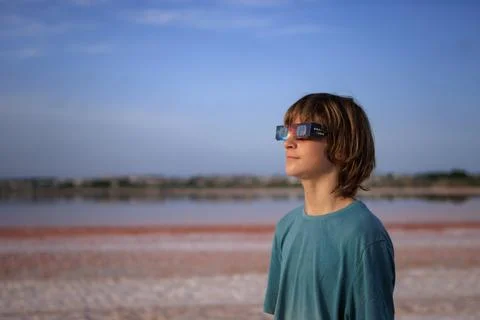 Young boy wearing special eclipse glasses safely observing a solar eclipse .. Stock Photos