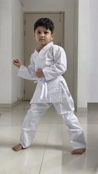 Young boy in white karate uniform confidently poses in a martial arts stance Stock Photos