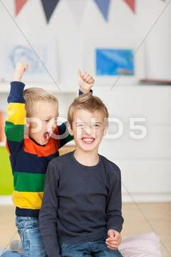 Young boy with wild brother raising arms Stock Photos