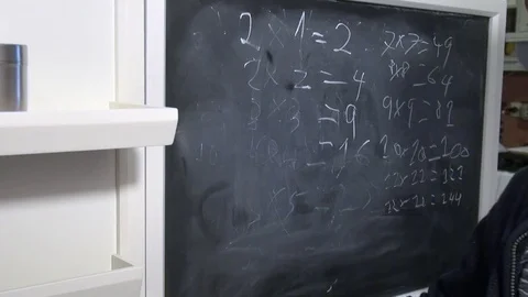 Young boy wiping a chalkboard with math on it Stock Footage 71962991