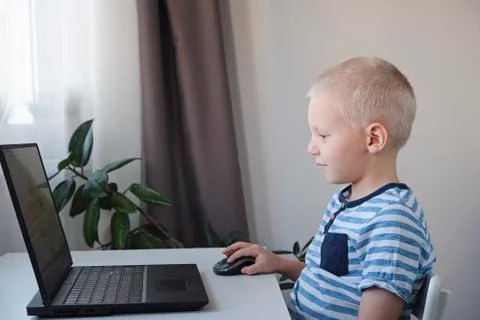 Young boy working on a computer at home. E-lessons, education, programming or Stock-Fotos