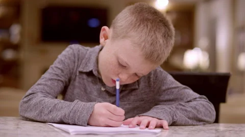 A young boy working on homework at the kitchen counter Stock Footage 63221082