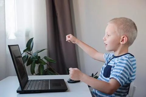 Young boy working or playing on a computer at home. E-lessons, education Stock-Fotos