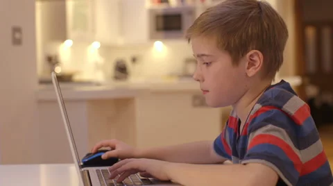 Young boy works on his laptop at home Stock Footage 46548648