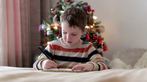 Young boy writes a letter to Santa. Stock Footage 233372136