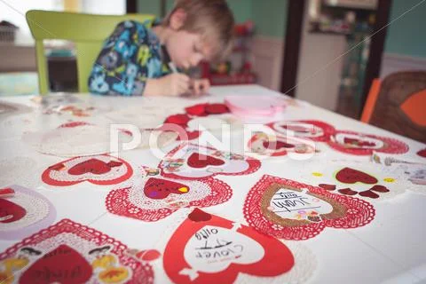 Young boy writing out valentine cards Stock Photos