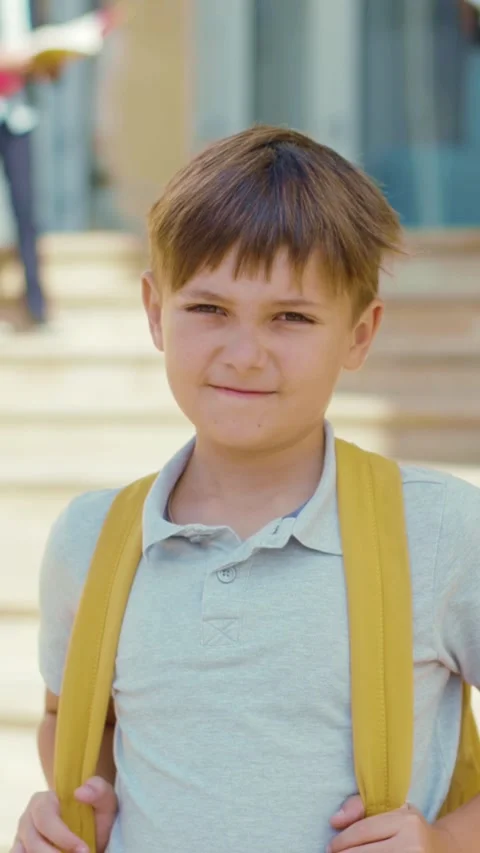 A young boy with a yellow backpack excitedly heads to school Stock Footage 316512015