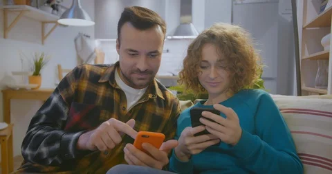 Young boyfriend and girlfriend using smartphones at home Stock-Footage 128080487