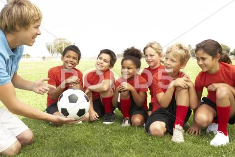 Young Boys And Girls In Football Team With Coach Stock Photos