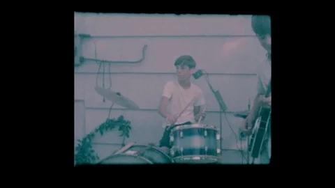 Young boys in band perform in backyard for neighbors Stock Footage