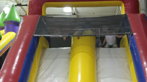 Young boys falling down an inflated ramp playground Stock Footage 37274538