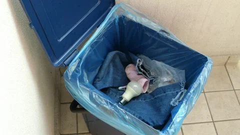 A Young Boy’s Hand Throws Light Bulb Into A Mixed Waste Bin. 4K Stock Footage 253185995
